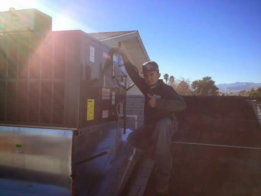 HVAC technician performing AC Tune-Up on a rooftop unit in Cortez